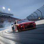 A NASCAR stock car speeds through a banked turn at Richmond Raceway at night under stadium floodlights.